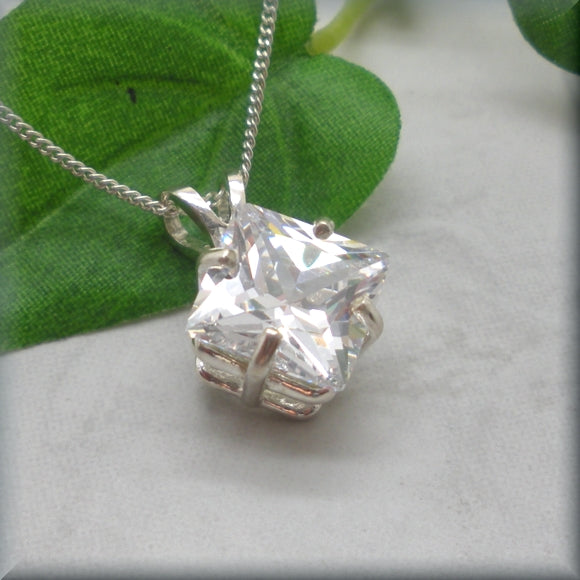 White CZ necklace set in sterling silver displayed against a leaf